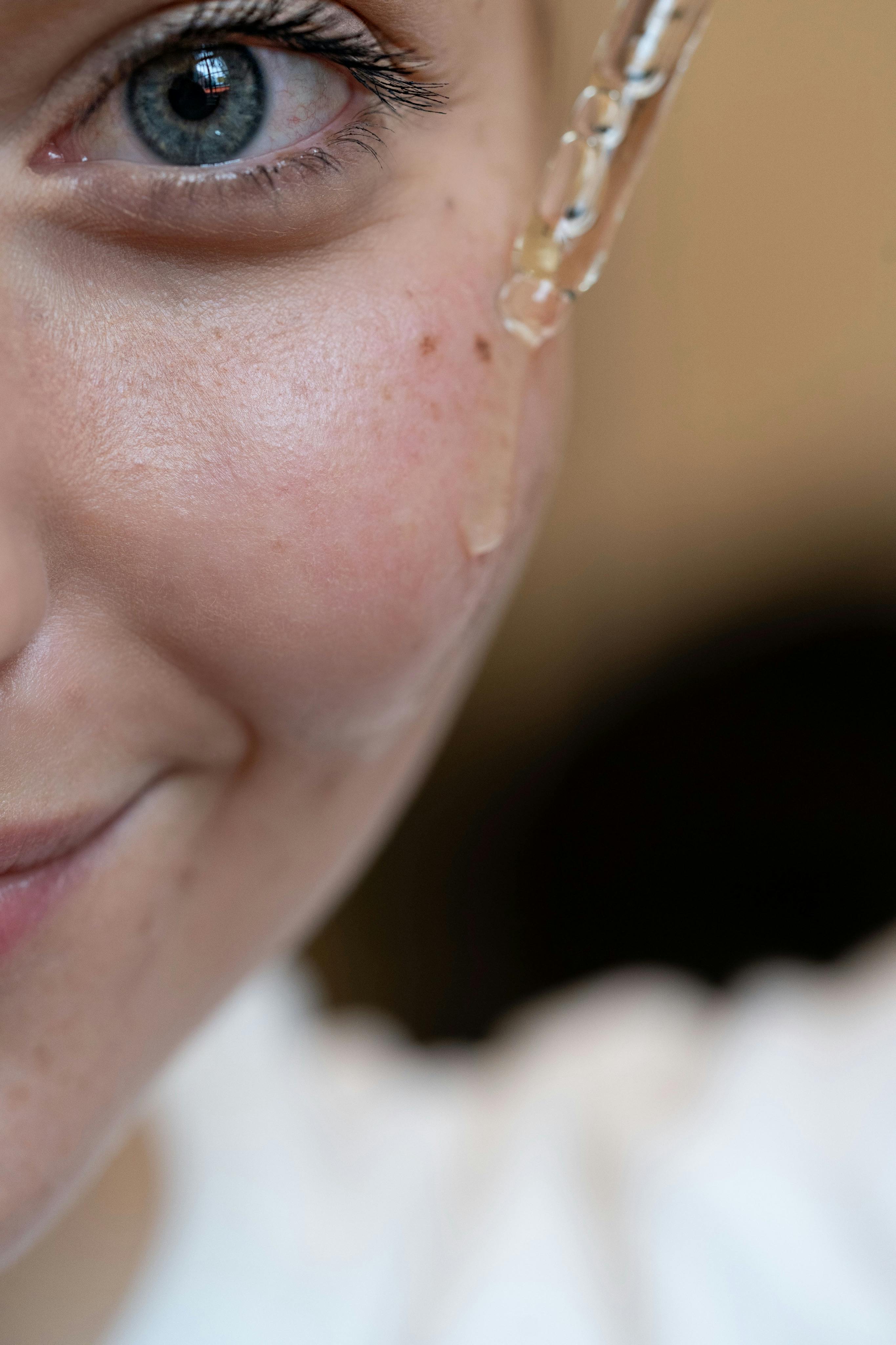 Aplicación de sérum facial con gotero, paso clave de una rutina dermatológica para manchas y signos de edad